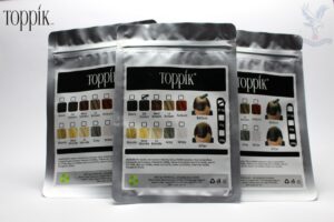 Pouring Toppik Hair Fiber 27.5g into bottle with sifter lid for thinning hair.